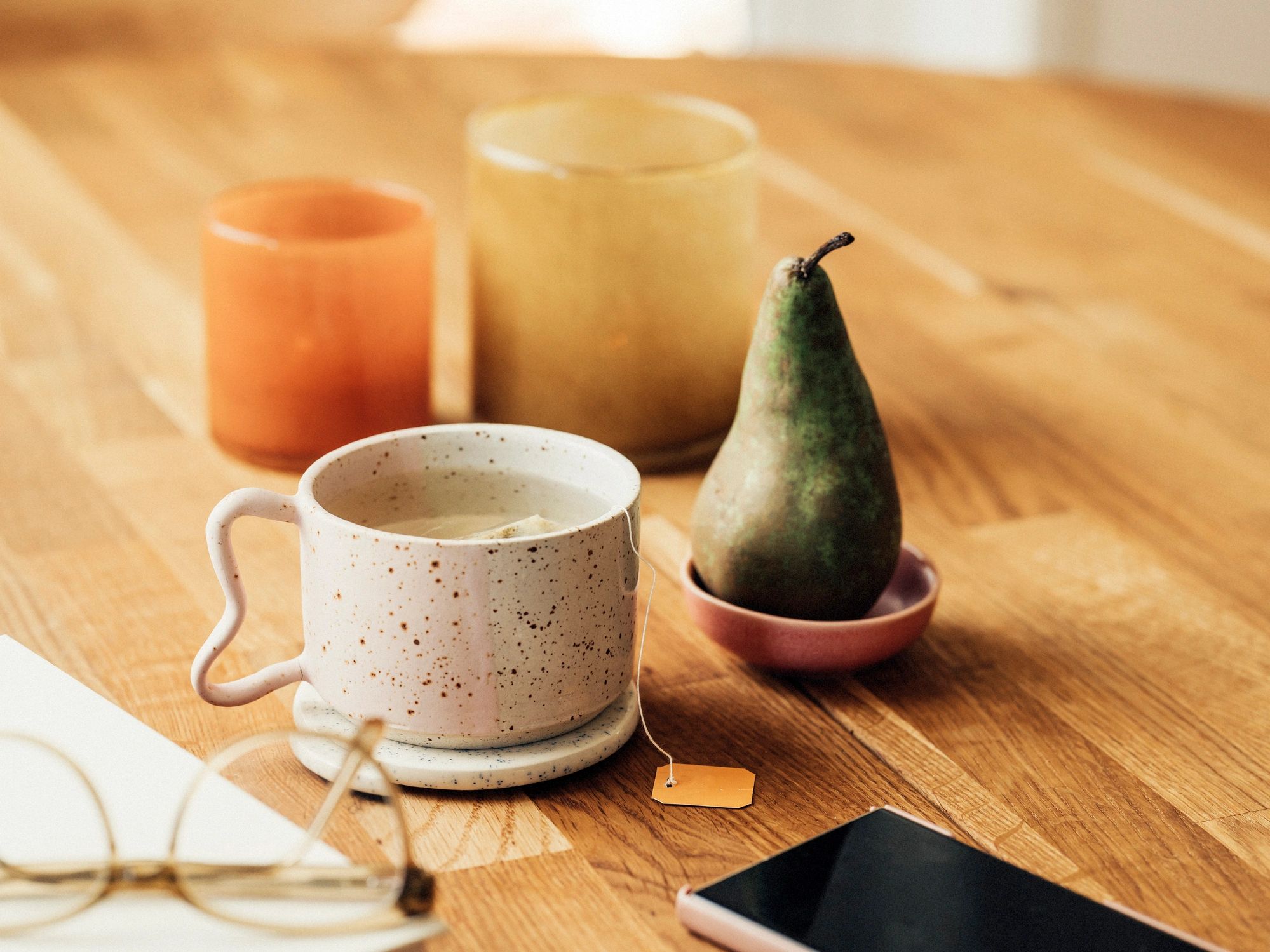 A warm tea setting with candles and a book