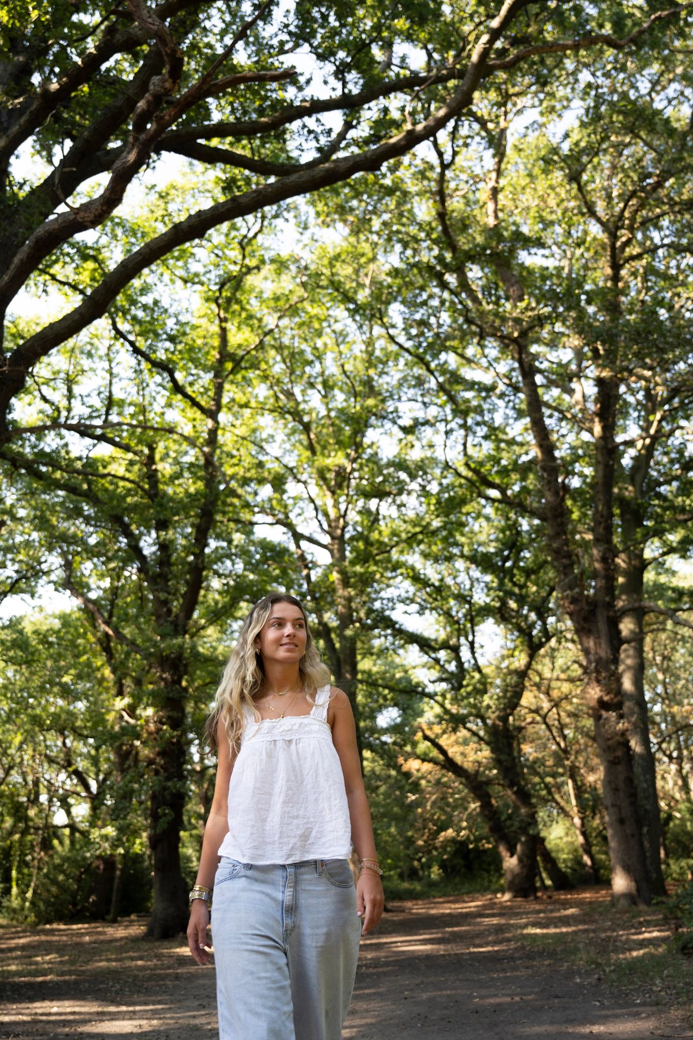 Woman walking peacefully through a sunlit forest